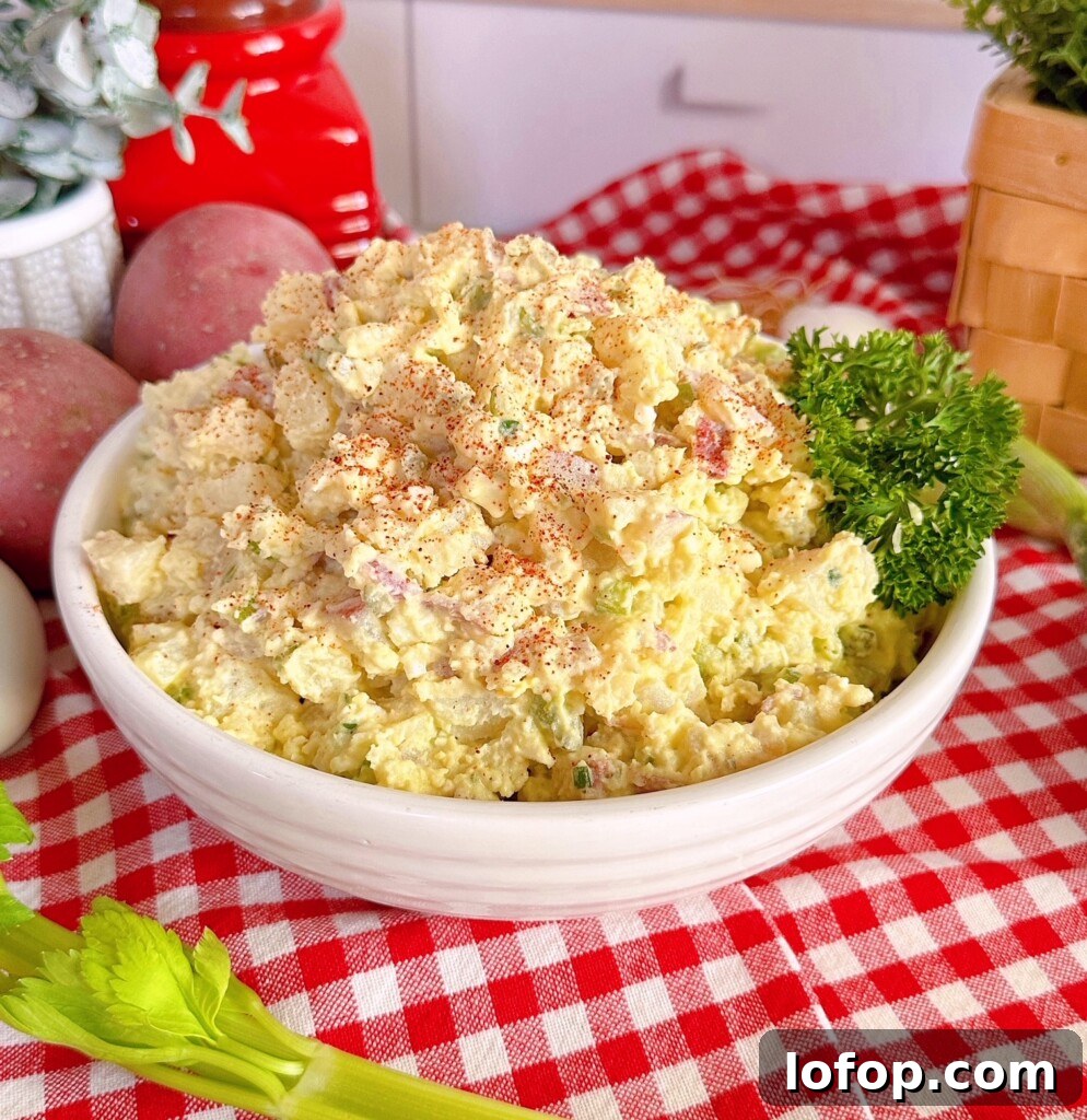 Classic Red Potato Salad in a serving dish on a red and white checkered cloth.
