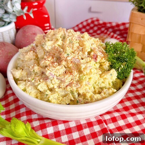 Classic Red Potato Salad in a serving dish on a red and white checkered cloth.