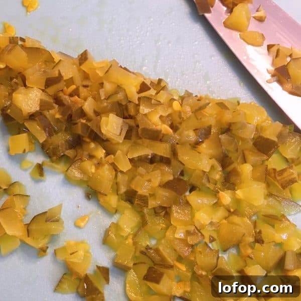 Diced Dill pickles on the cutting board with the knife