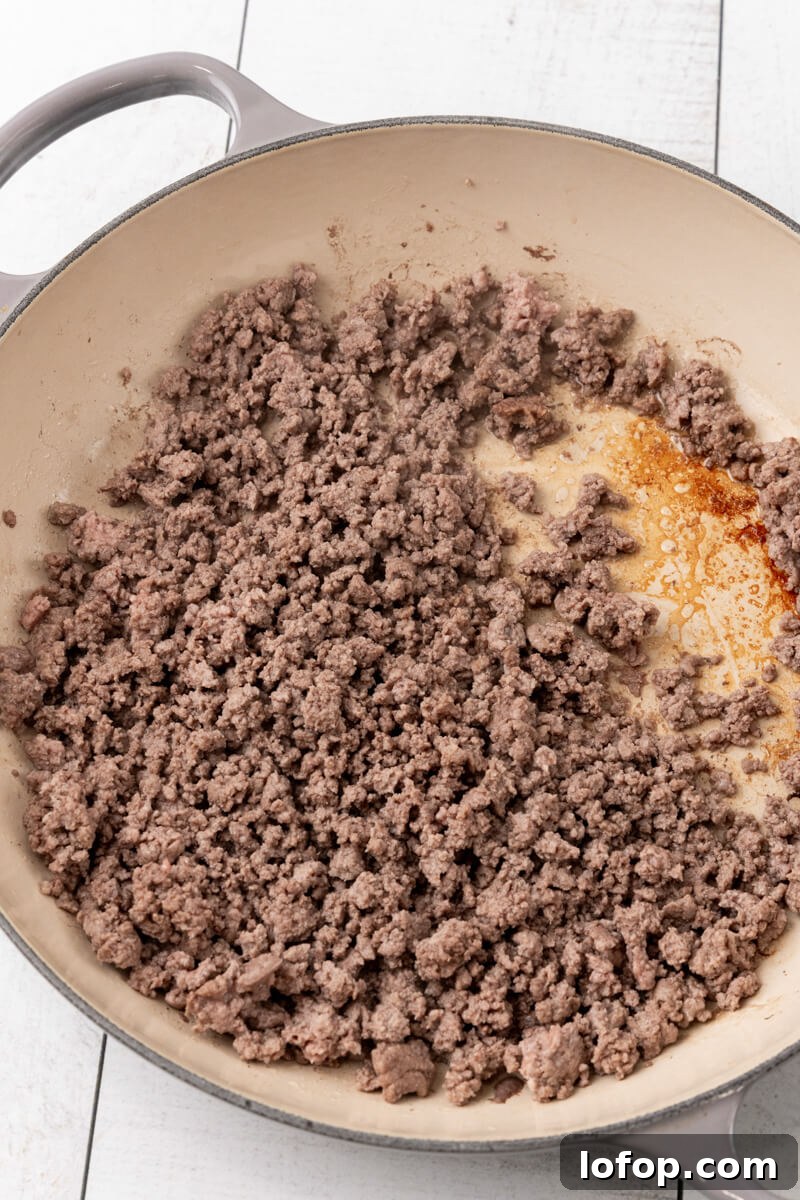 A skillet full of browned and drained ground beef.