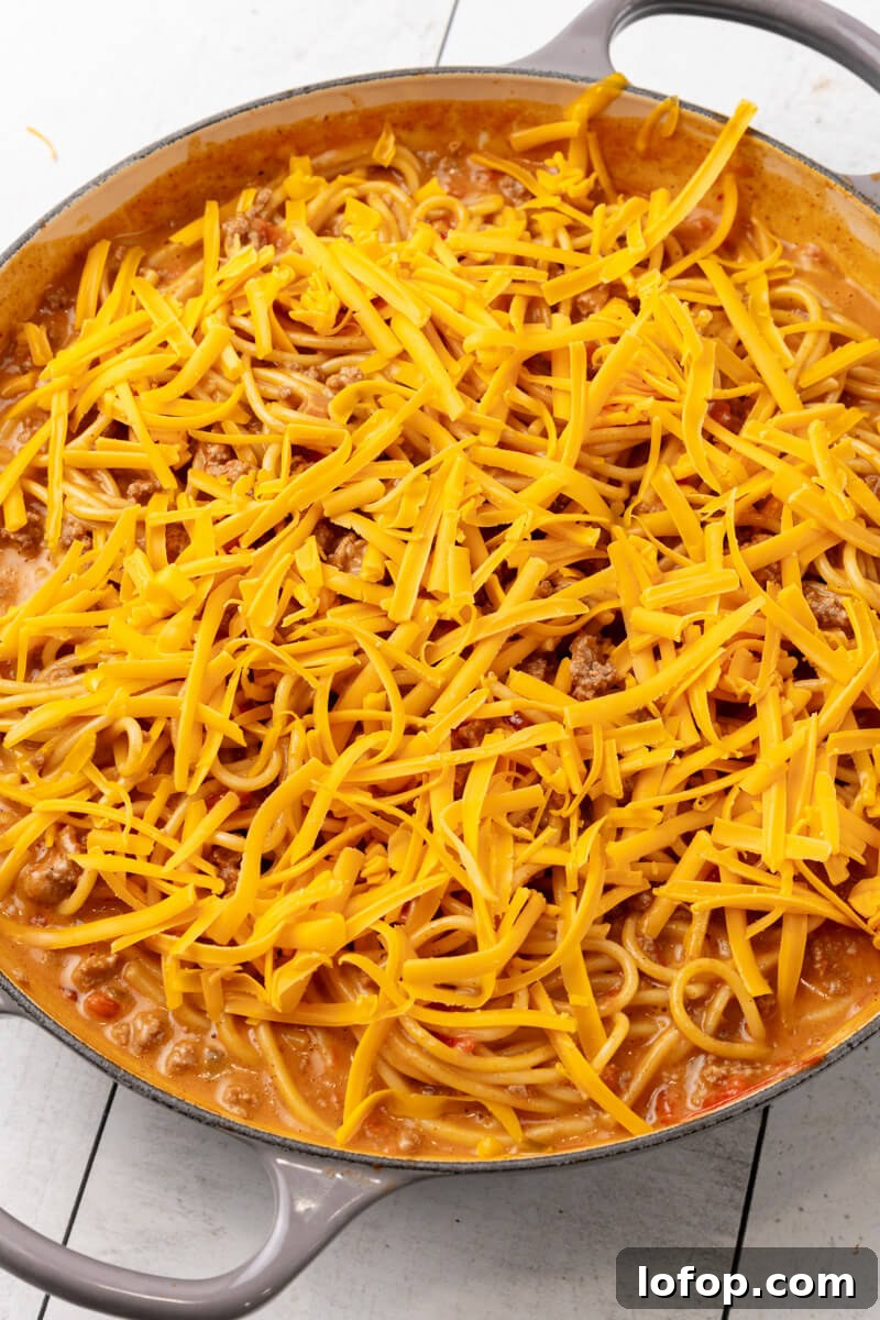 Shredded cheddar cheese is added on top.
