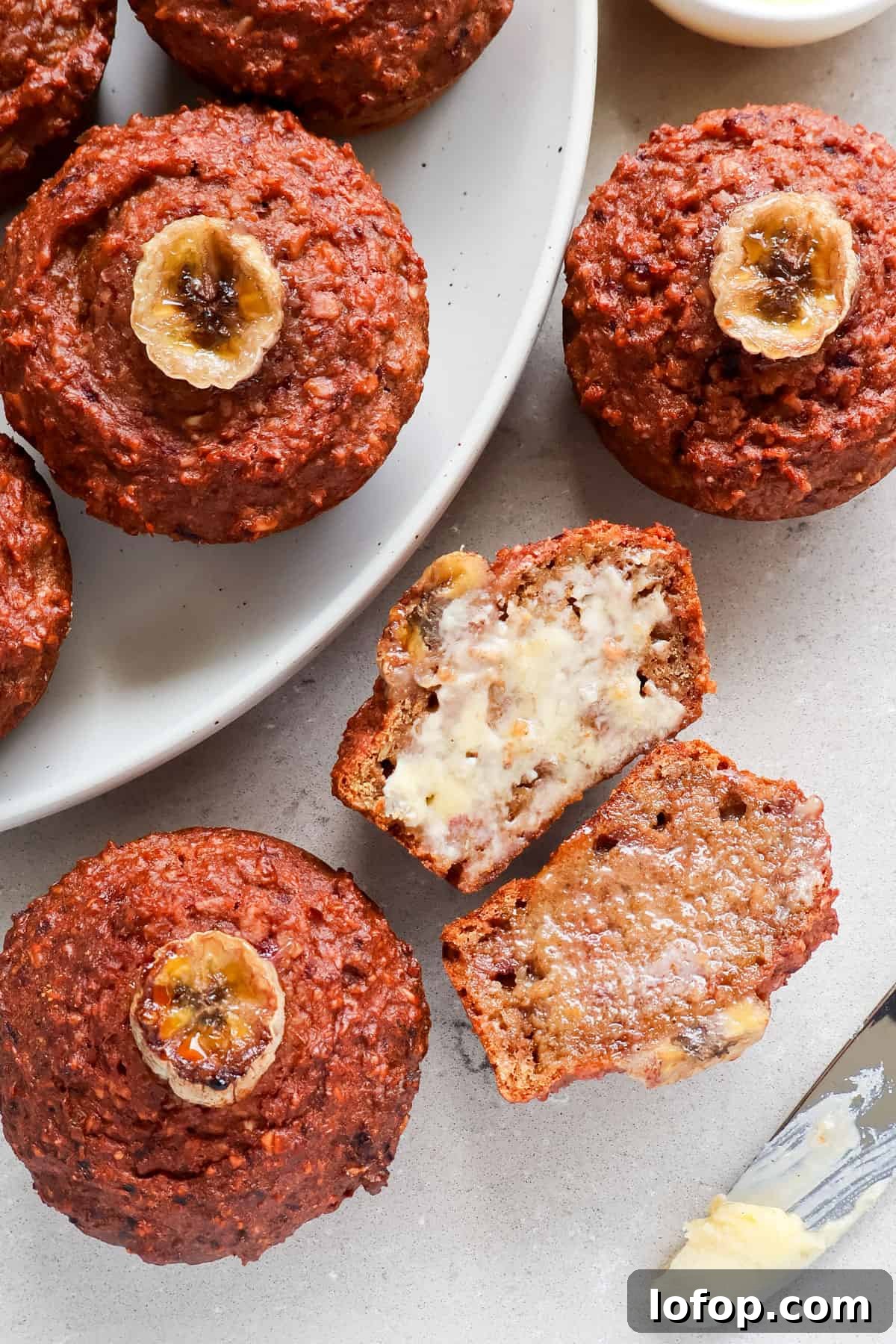 Close up shot of a muffin cut in half spread with butter.