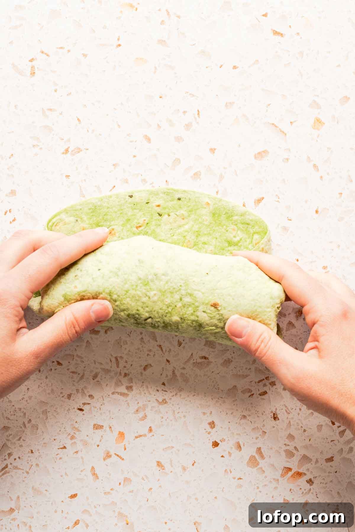 Crispy Tuna Melt Wrap Recipe for Quick Lunches 11 tuna wrap being rolled up into burrito shape.