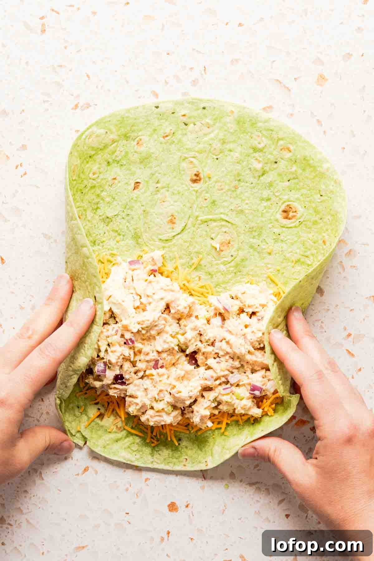 Crispy Tuna Melt Wrap Recipe for Quick Lunches 9 sides of tortilla being folded in with hands.