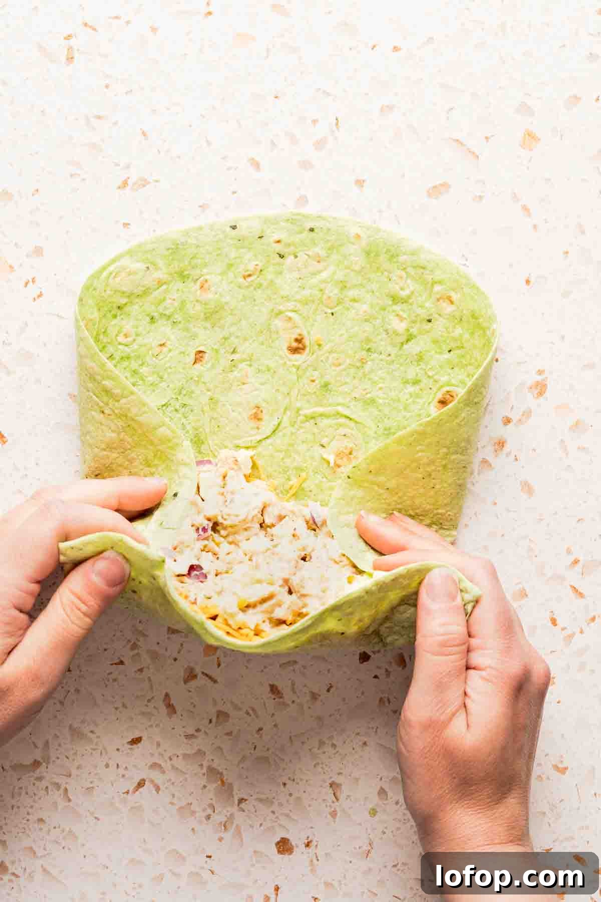 Crispy Tuna Melt Wrap Recipe for Quick Lunches 10 tuna melt wrap being rolled with sides tucked in.