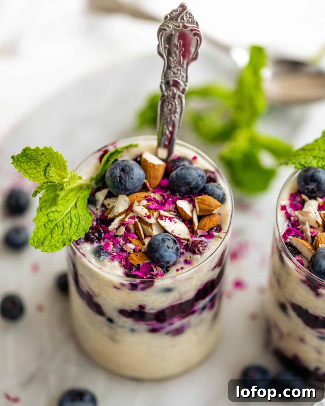 cups of rice pudding with almonds and blueberries on top