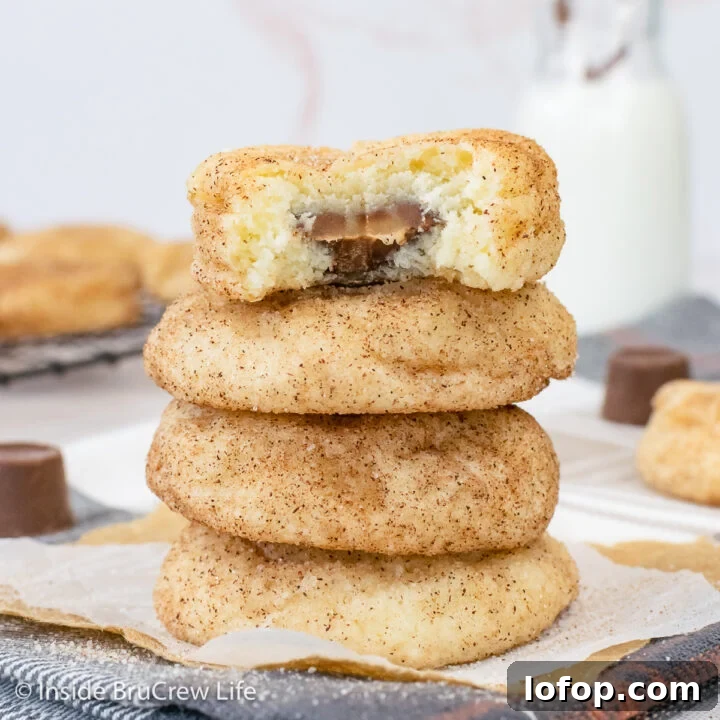A stack of cinnamon sugar cookies stuffed with Rolo candies on a towel.