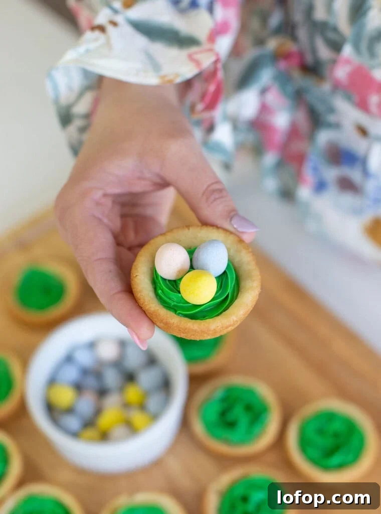 Easter birds nest cookie cup with green frosting for grass, and chocolate eggs.