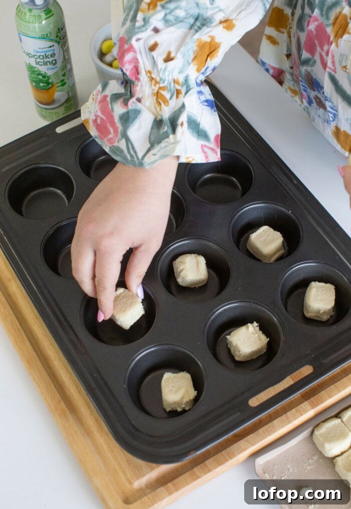Sugar Cookie dough being put into cupcake pan.