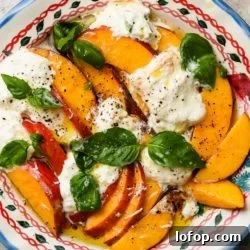 Peach and Burrata Caprese Salad with Balsamic Glaze 6 Fresh peach and burrata salad with basil, in a decorative bowl.
