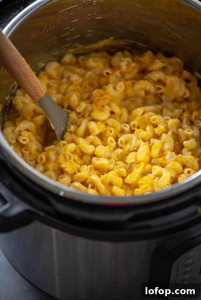 butternut squash Mac and cheese in instant pot with spoon to stir