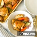 Sheet pan chicken thighs plated with roasted vegetables and fresh herbs.