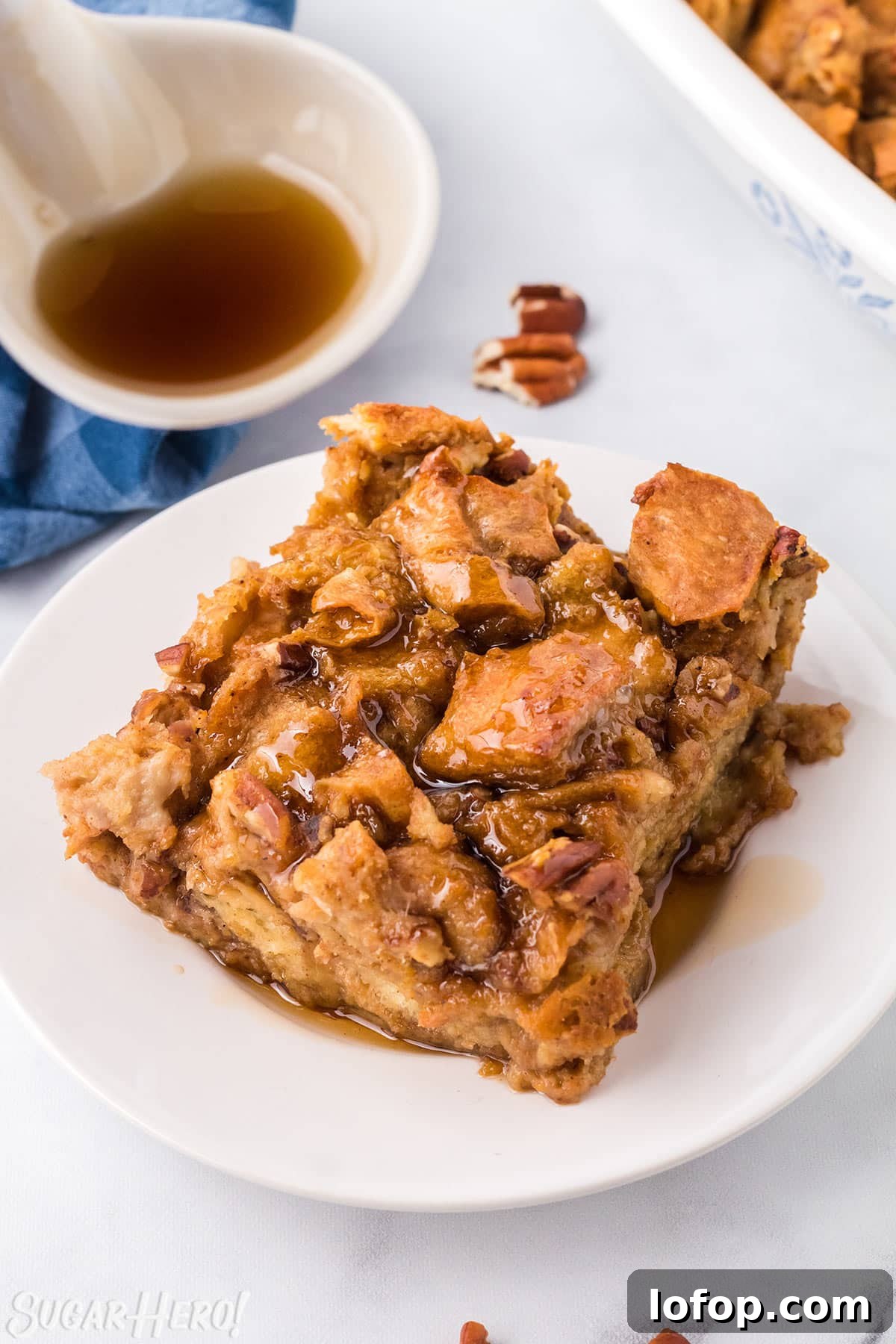 Creamy Pumpkin Bread Pudding with Spiced Caramel Sauce 2 Slice of Pumpkin Bread Pudding on a white plate, drizzled with cinnamon syrup.