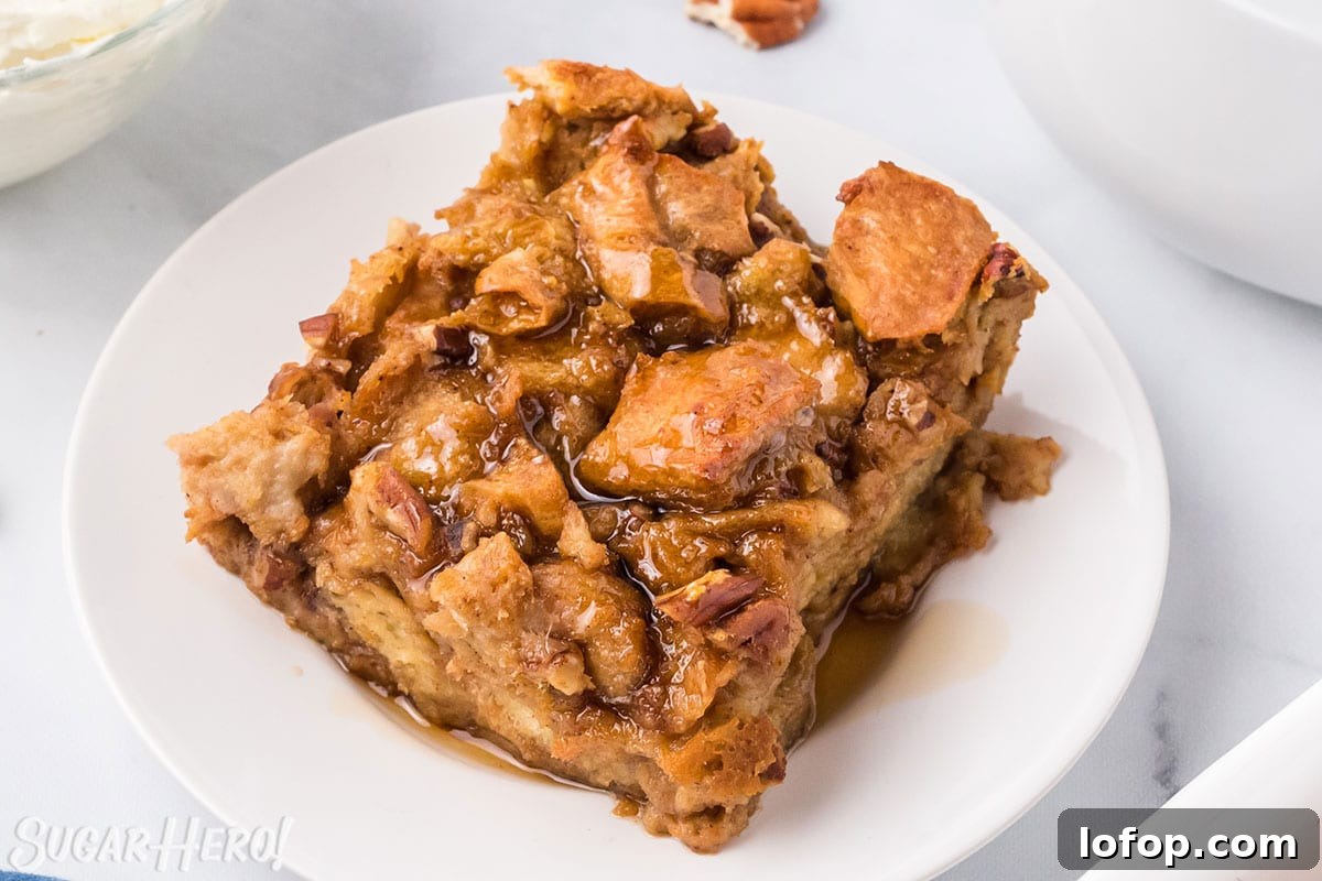 Creamy Pumpkin Bread Pudding with Spiced Caramel Sauce 8 Slice of Pumpkin Bread Pudding on a white plate, drizzled with cinnamon syrup.