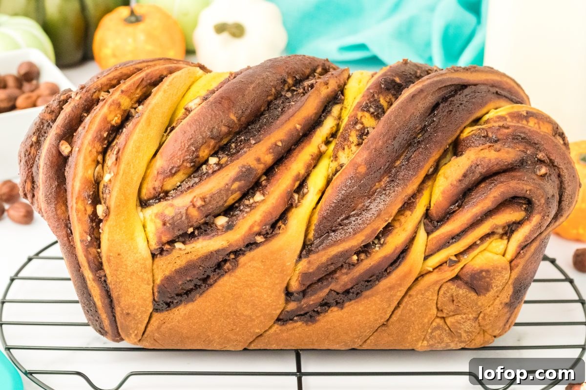 Side view of pumpkin bread with swirls of chocolate Nutella and chopped hazelnuts. Hostess At Heart