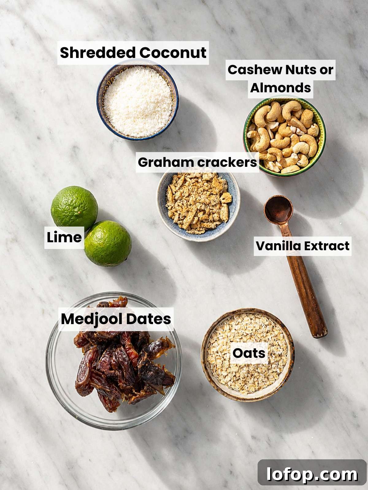 Medjool dates, oats, cashews, coconut, lime, and graham crackers on marble.
