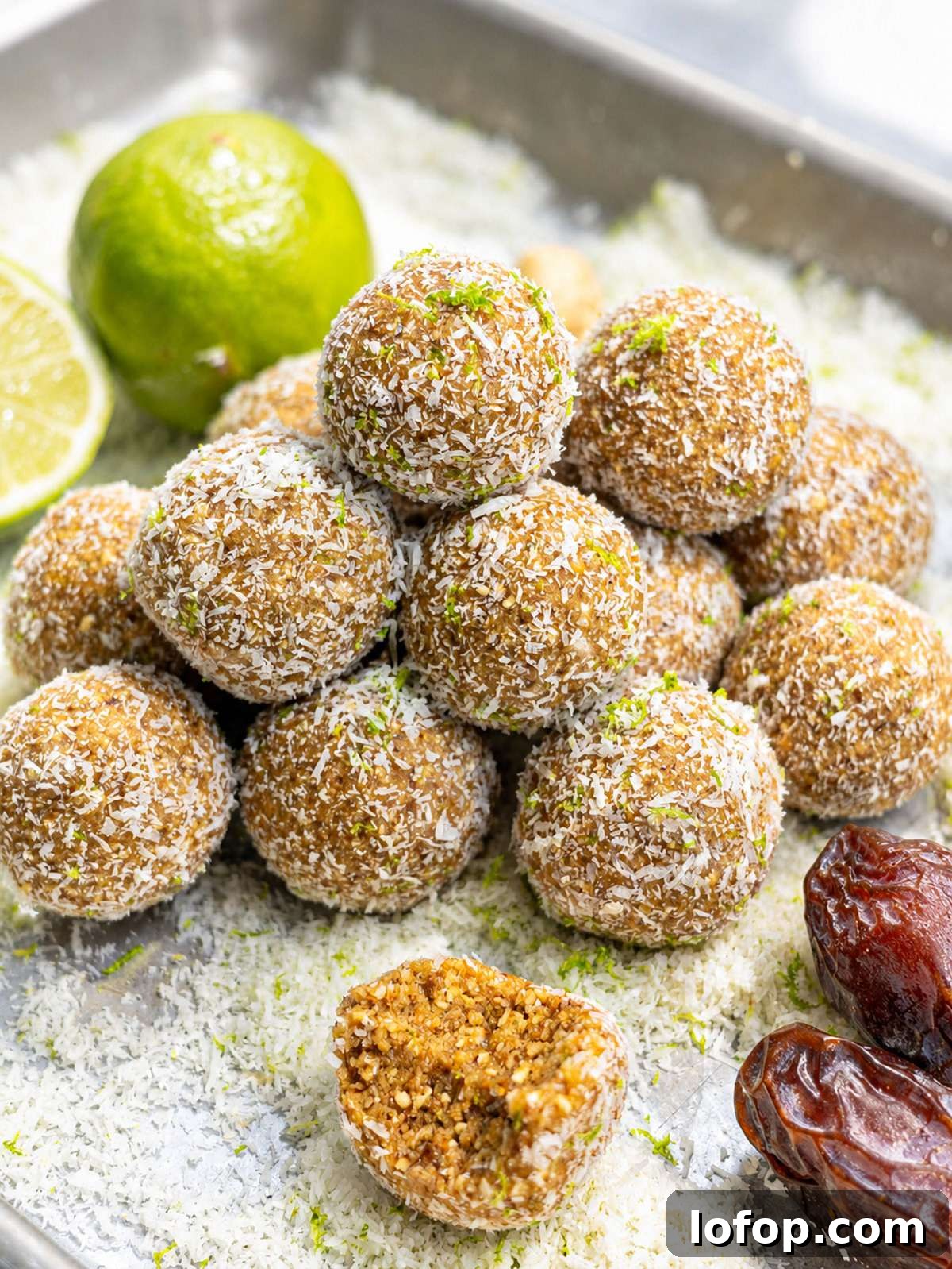Key lime pie energy balls coated in coconut with lime zest and soft date filling.