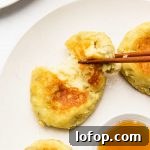 japanese sweet potato cheese mochi, stuffed with cheese and cutting it in half on a white plate served with maple syrup in a bowl