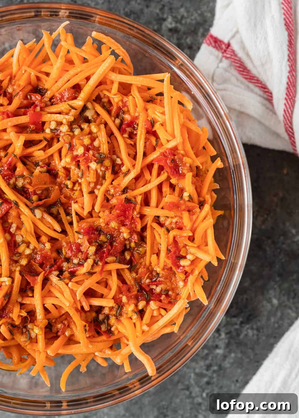 overhead: shredded raw carrot salad in glass bowl