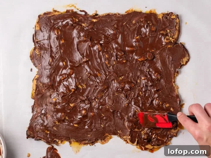 Melted chocolate spread across the top of the peanut butter date bark layer