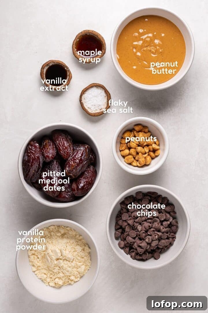 Labeled ingredients for a date bark recipe including dates, peanut butter, chocolate chips, peanuts, maple syrup, vanilla, and flaky salt