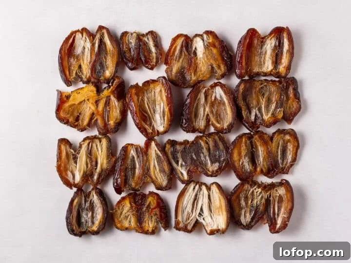 Pitted dates arranged in rows on parchment paper
