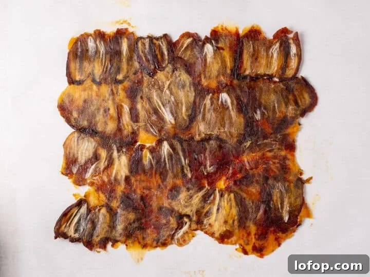 Flattened dates pressed together into one even layer on parchment paper