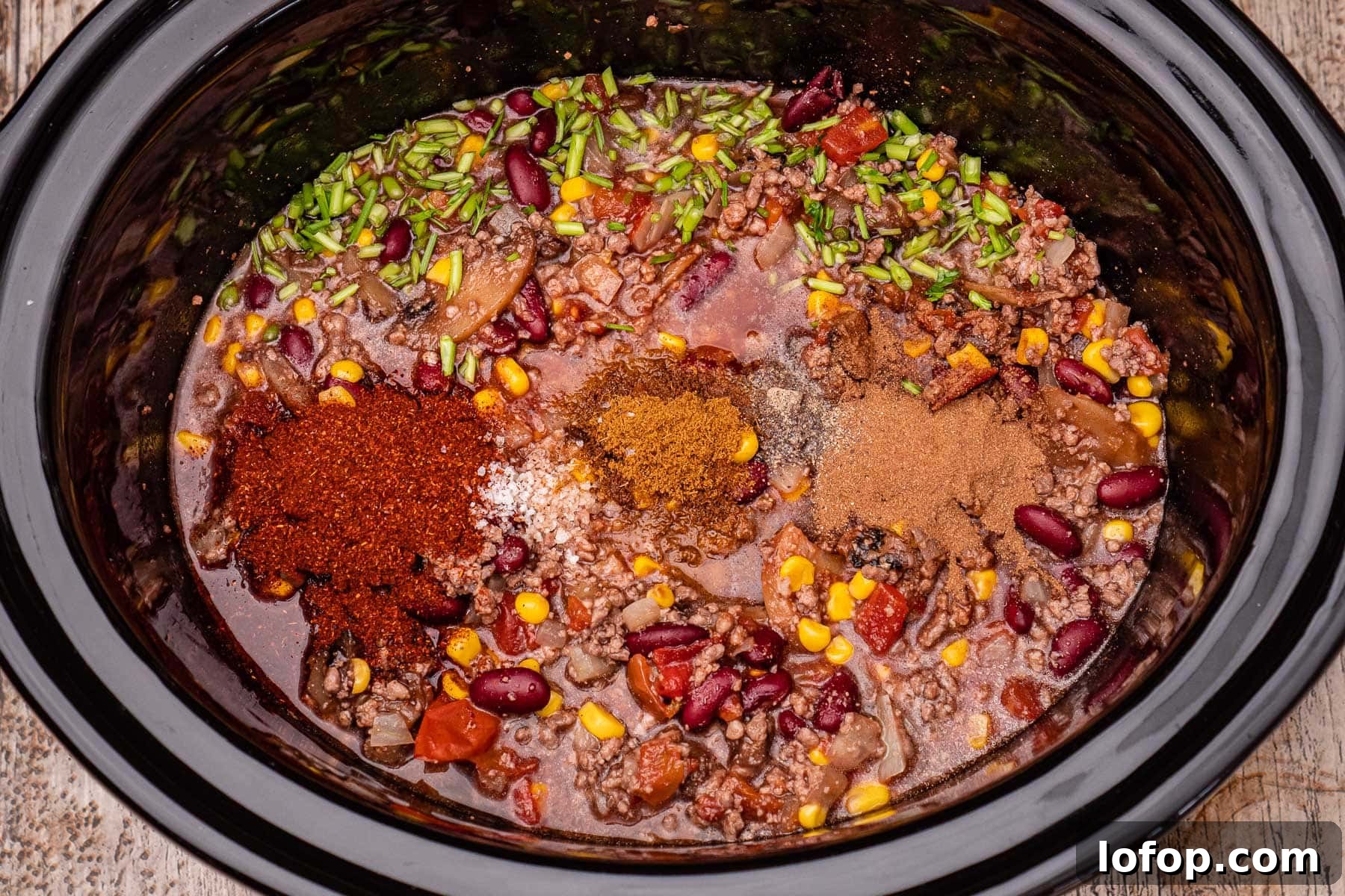 Hot chilli powder, salt, ground cumin, black pepper and ground cinnamon on top of our slow cooker chilli