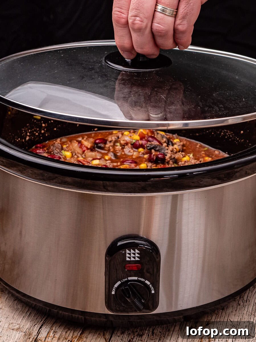 Placing the lid on top of our slow cooker with our chilli con carne inside the pot