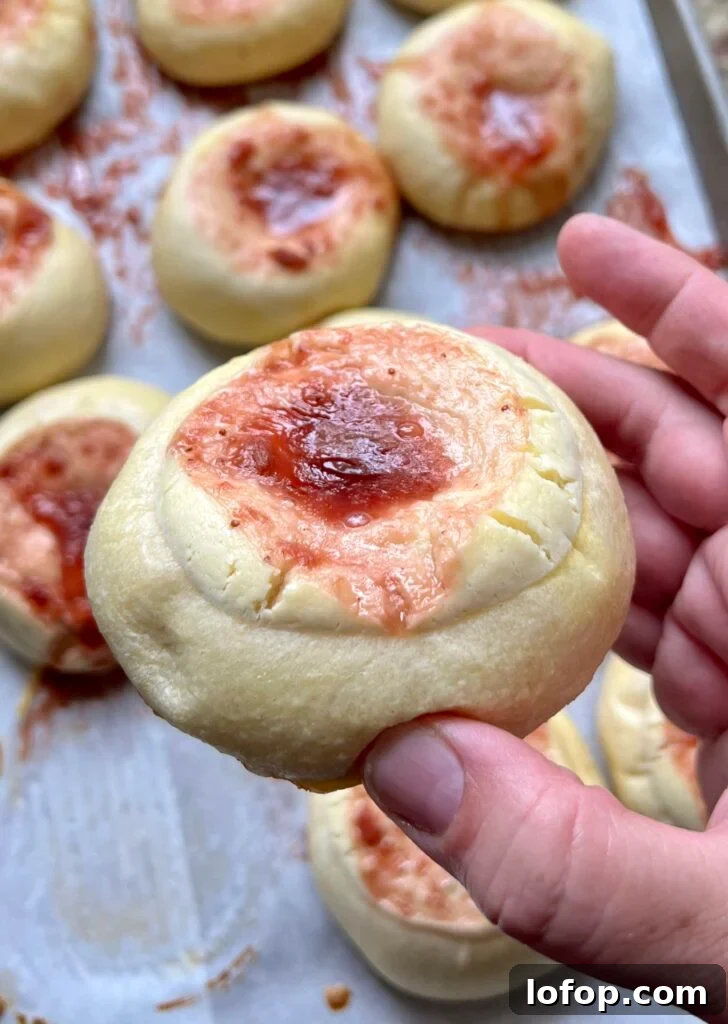 Close-up of a baked sourdough kolache with fruit jam center and cream cheese filling.