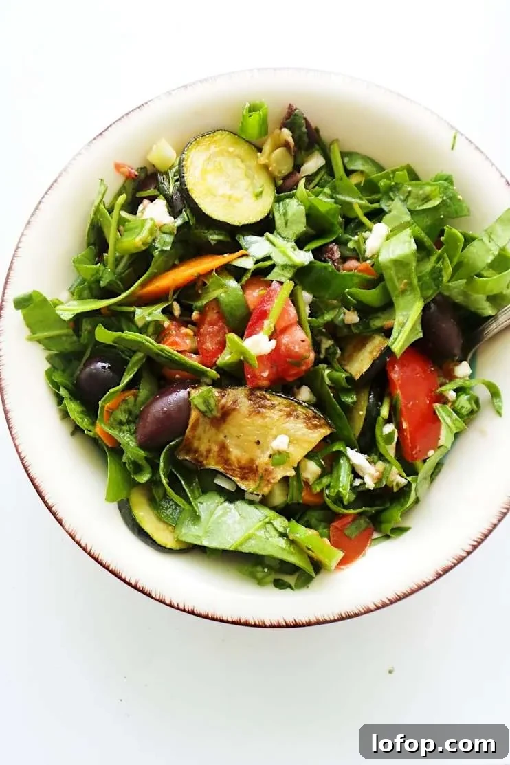 A refreshing and satisfying healthy and easy summer salad with tomatoes, feta cheese, greens, grilled vegetables
