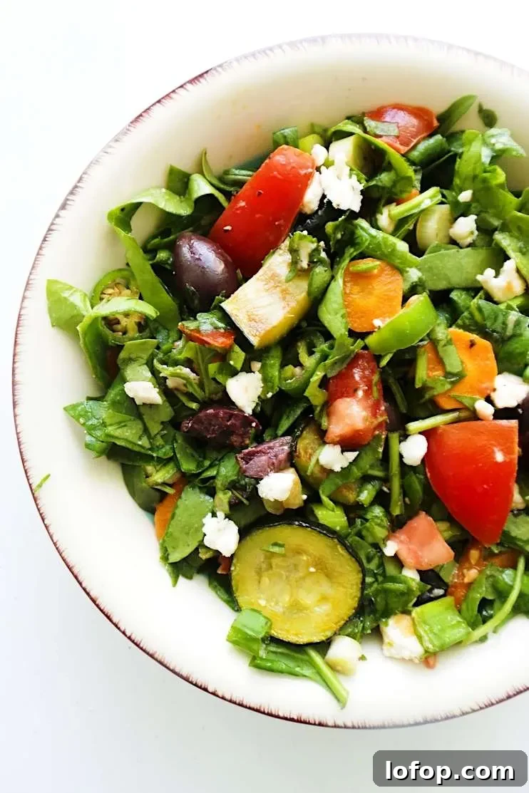 A refreshing and satisfying healthy and easy summer salad with tomatoes, feta cheese, greens, grilled vegetables