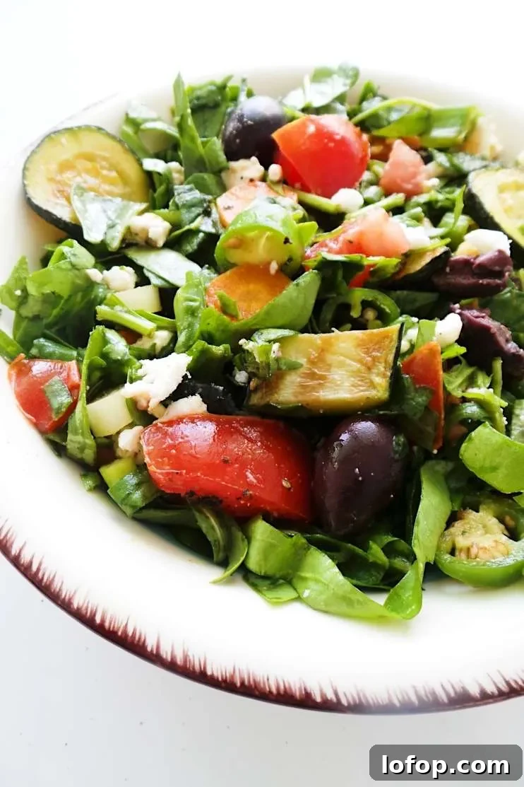 A refreshing and satisfying healthy and easy summer salad with tomatoes, feta cheese, greens, grilled vegetables