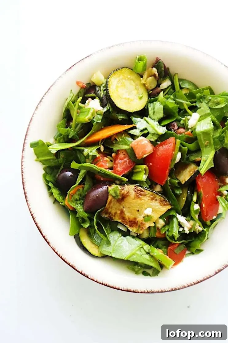 A refreshing and satisfying healthy and easy summer salad with tomatoes, feta cheese, greens, grilled vegetables