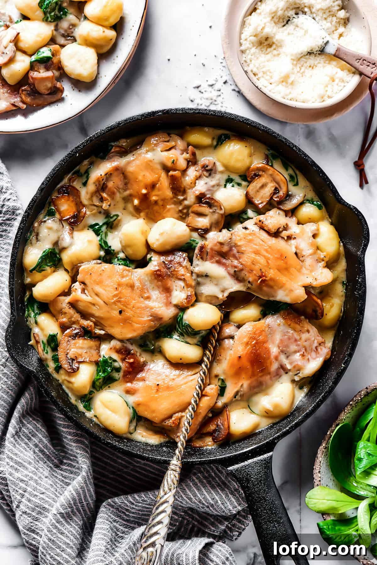 Creamy Chicken & Gnocchi is a bold, yet comforting combo of tender chicken, pillowy gnocchi, and flavorful spinach and mushrooms. Creamy chicken and gnocchi in a cast-iron skillet.