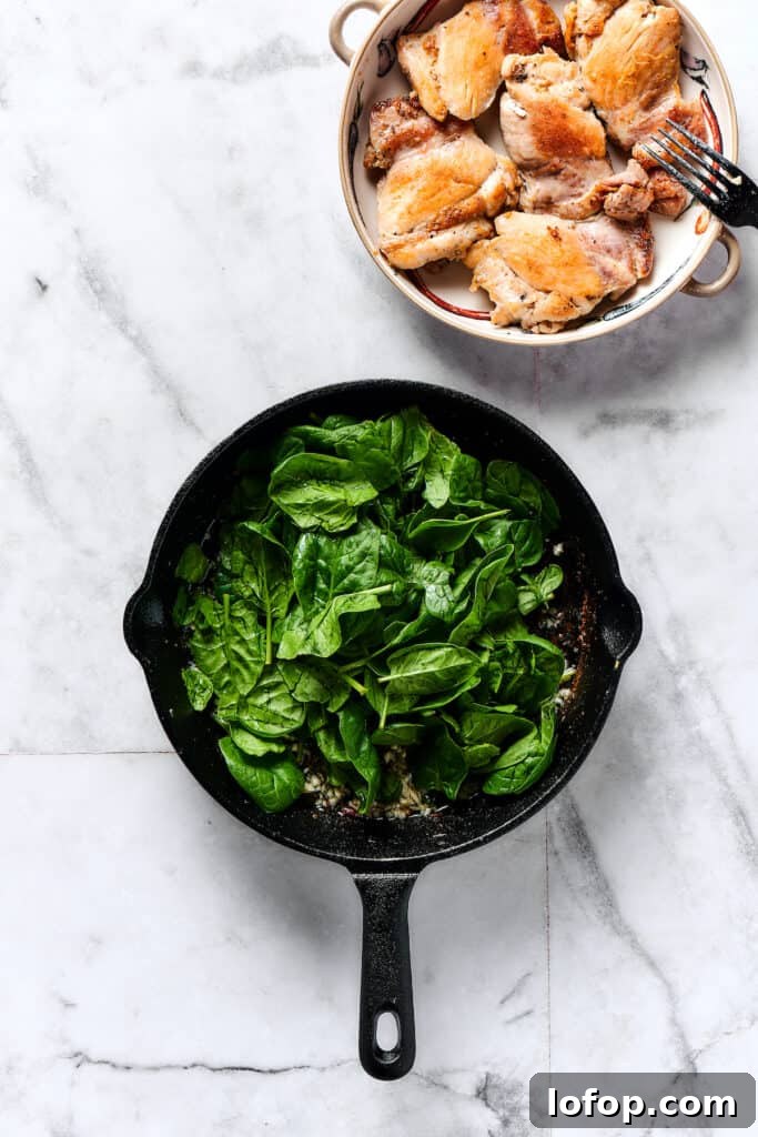 Creamy Chicken and Gnocchi Skillet with Garlic Parmesan Sauce 3 Baby spinach cooking in a skillet.