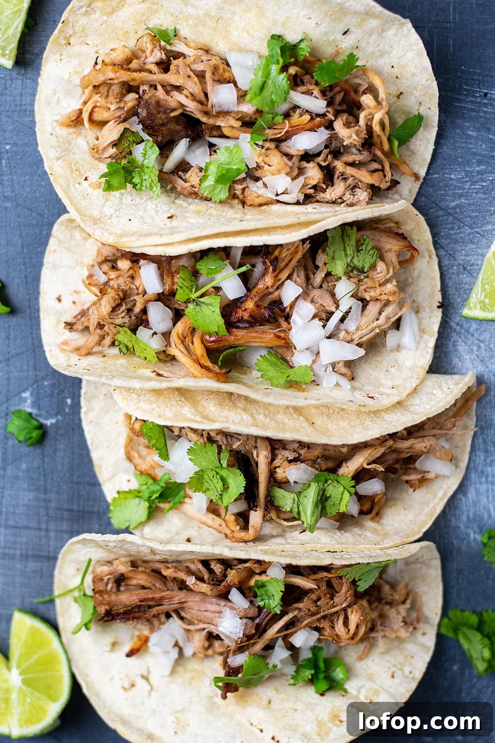 Slow Cooker Pork Carnitas Tacos Recipe for Tender Flavor 2 Four pork carnitas tacos topped with white onion and cilantro.