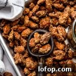 Cinnamon Sugar Candied Almonds Recipe | Crunchy Roasted Almonds 13 Aerial photo of a serving spoon scooping up candied almonds from a baking sheet.