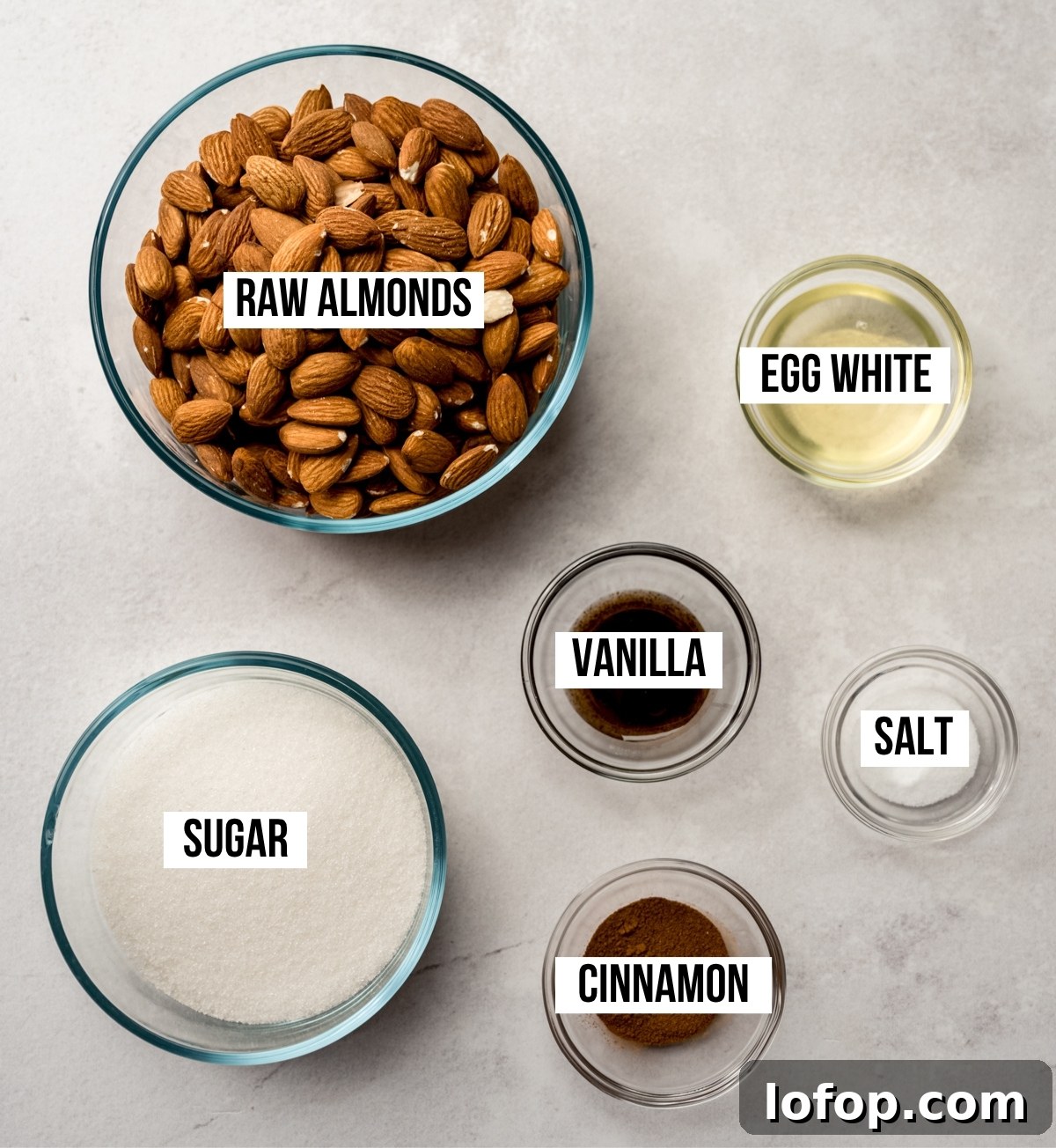 Cinnamon Sugar Candied Almonds Recipe | Crunchy Roasted Almonds 3 Aerial photo of ingredients to make candied almonds with text overlay labeling each ingredient.