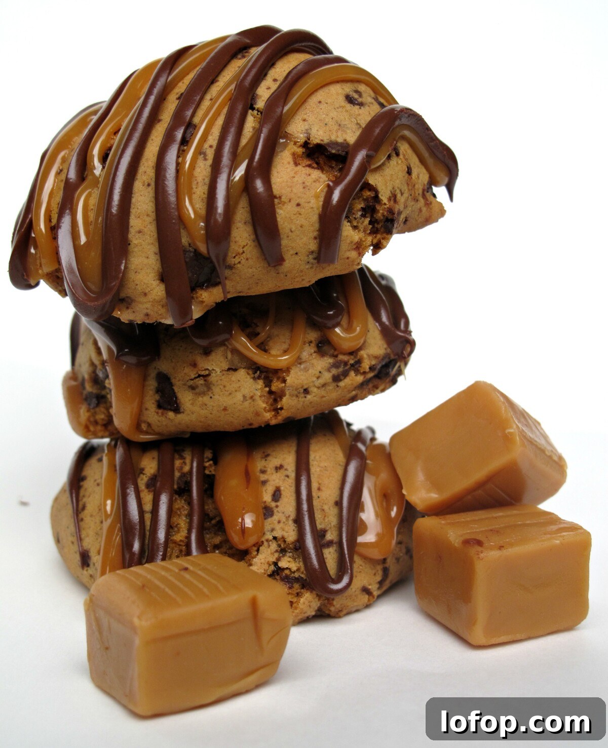 Stack of three cookies with zigzags of chocolate and caramel over the rounded tops.