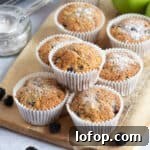 Apple and blackberry muffins on a wooden board.