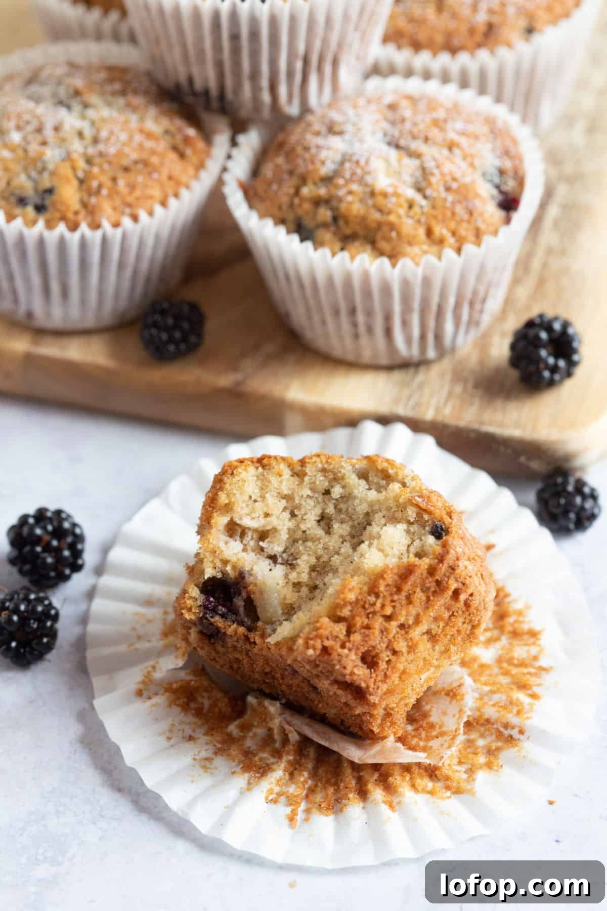 A half eaten muffin in its paper case.
