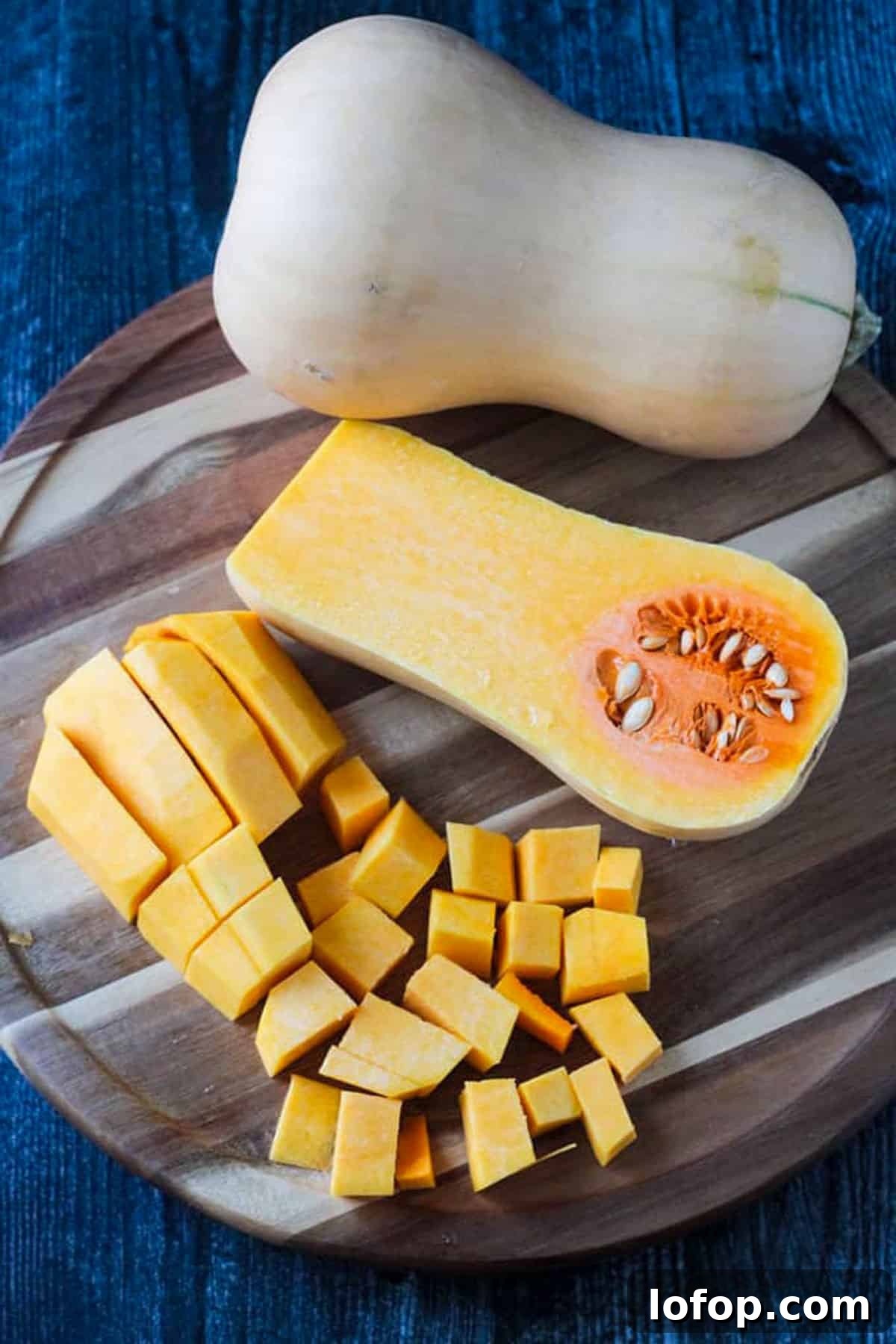 Butternut Squash Recipes for Fall: 15 Flavorful Ideas 3 One whole butternut squash, one half butternut squash cut side up, and cubed pieces of butternut squash on a round wooden cutting board.