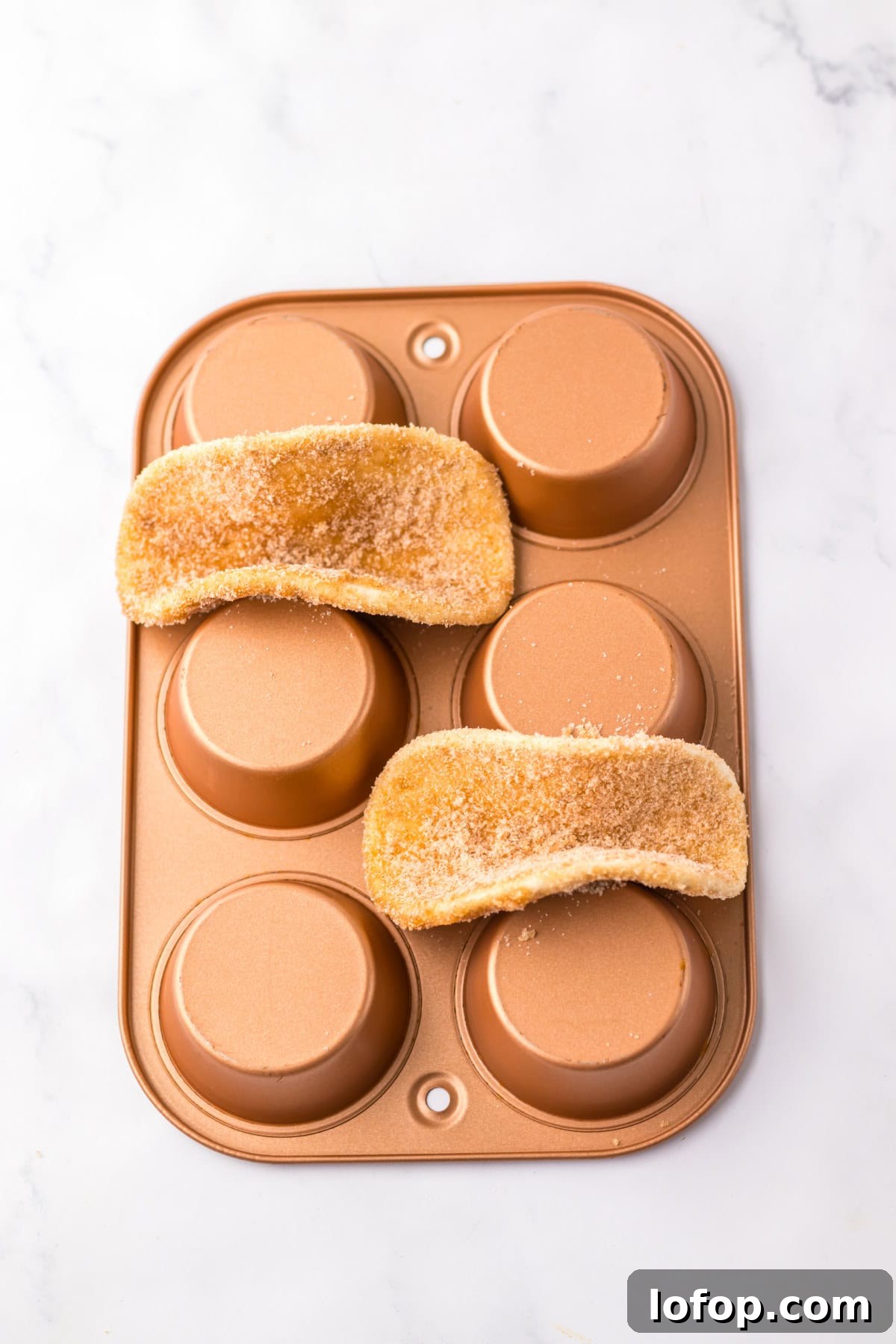 Taco shells placed on muffin tin for baking