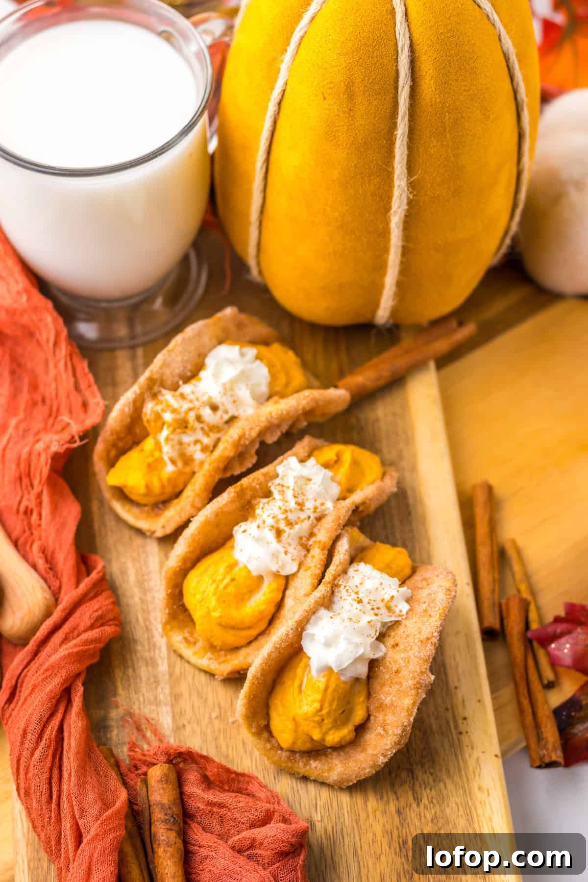 Three mini tacos filled with pumpkin filling and topped with whipped cream