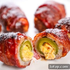 Crispy bacon-wrapped jalapeño poppers with creamy cheese filling on a white plate.
