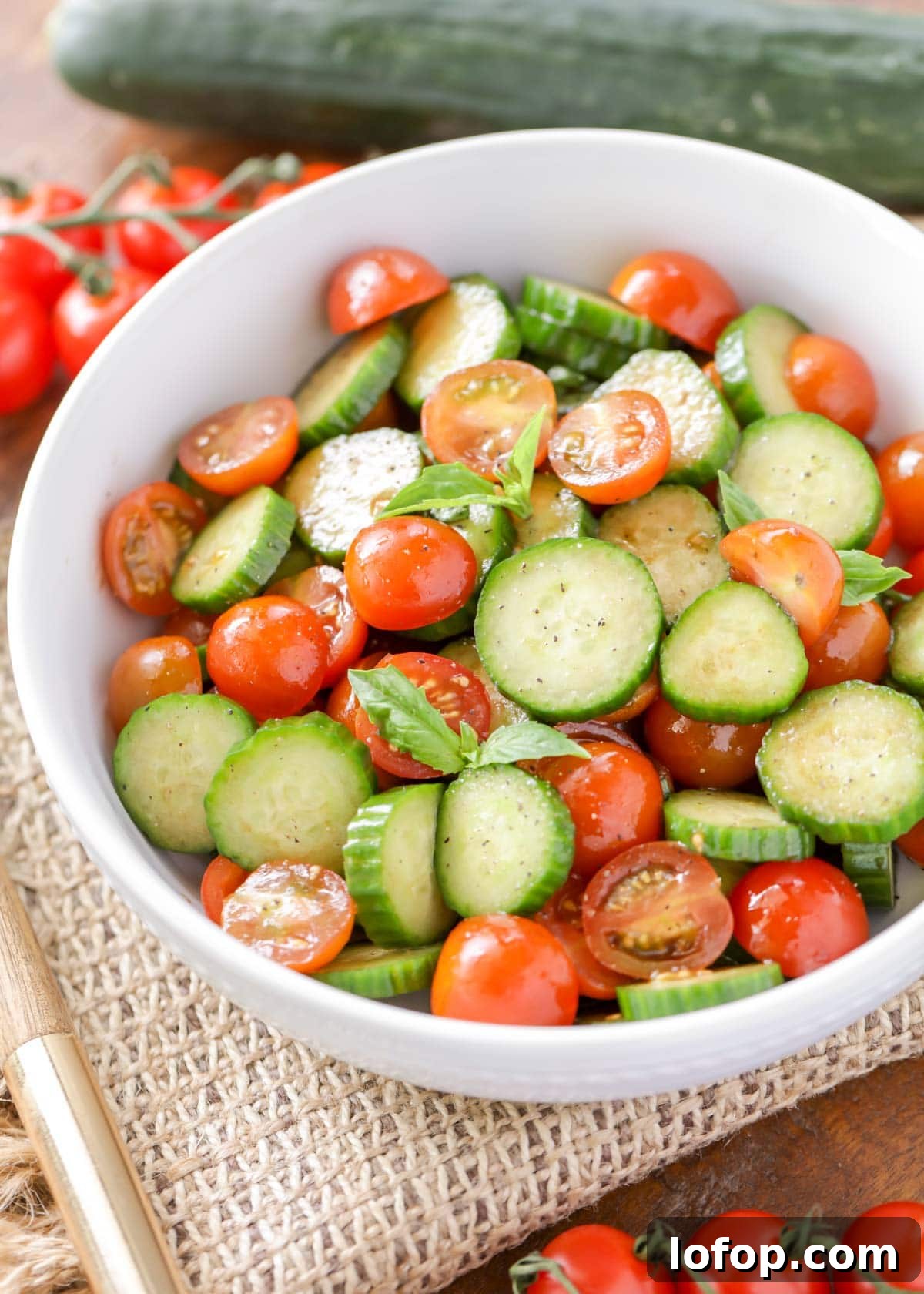 Fresh, vibrant Cucumber Tomato Salad is a simple salad perfect for summer and your bounteous harvest. It's a quick side for any meal! Fresh Cucumber Tomato Salad lightly dressed and served in a white bowl.