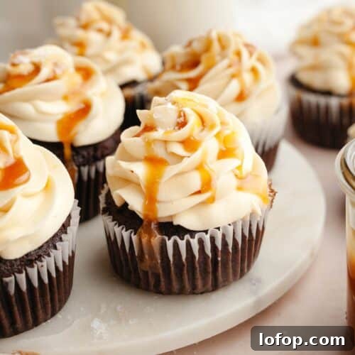 Chocolate cupcakes with caramel buttercream on white marble.
