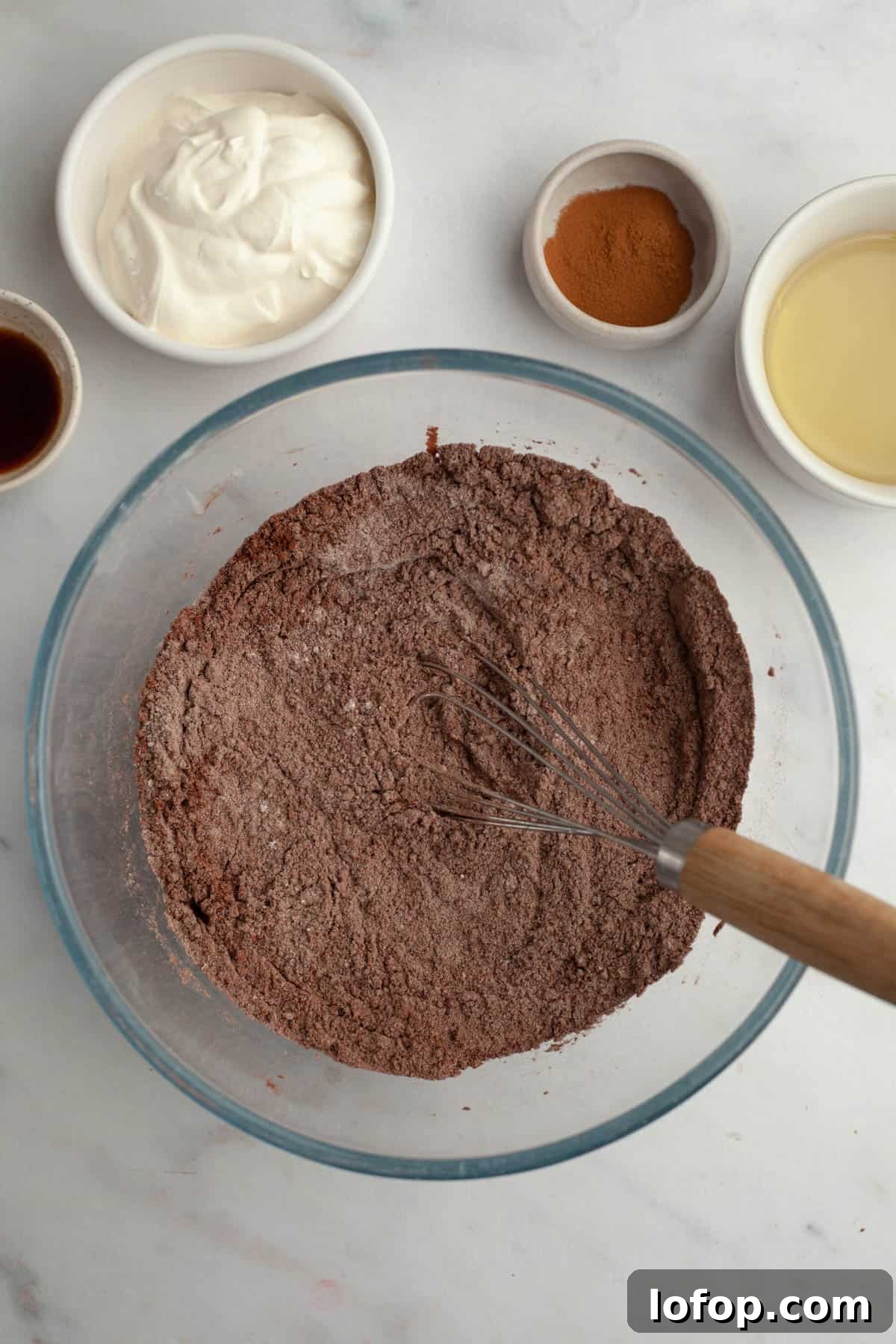 Decadent Chocolate Cupcakes with Cream Cheese Frosting 4 A glass bowl with whisked flour and cocoa powder.