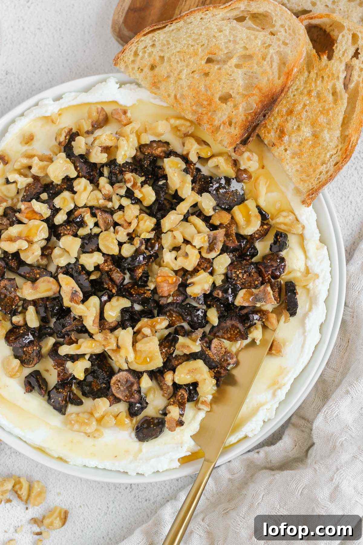 Whipped Goat Cheese and Honey Dip — 5-Ingredient Recipe 2 Whipped goat cheese topped with honey, sliced dried figs and walnuts on a small round plate. with a knife scooping up some of the spread and 2 pieces of toast on the side.